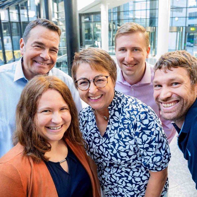 Ein Team aus fünf Personen macht ein Selfie