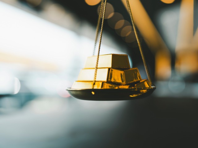 Godbarren auf einer Waage Goldpreis