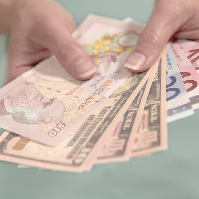 Hände halten amerikanische britische und europäische Währung