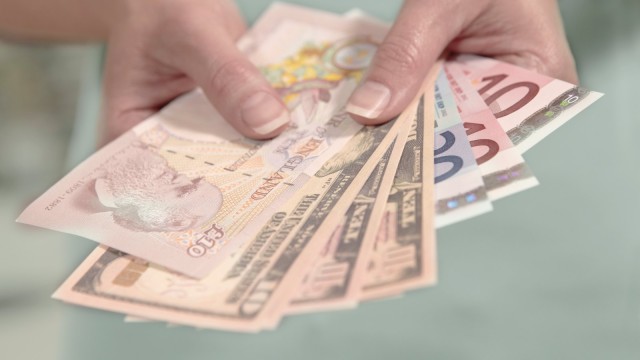 Hände halten amerikanische britische und europäische Währung