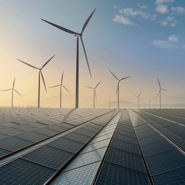 Sonnenkollektoren und Windr&auml;dern bei Sonnenaufgang