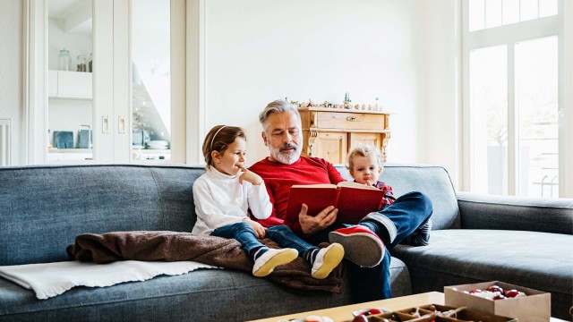 Großvater sitzt auf dem Sofa mit seinen Enkeln