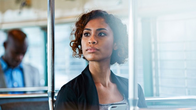 Eine Frau sitzt in der U-Bahn im Halbschatten