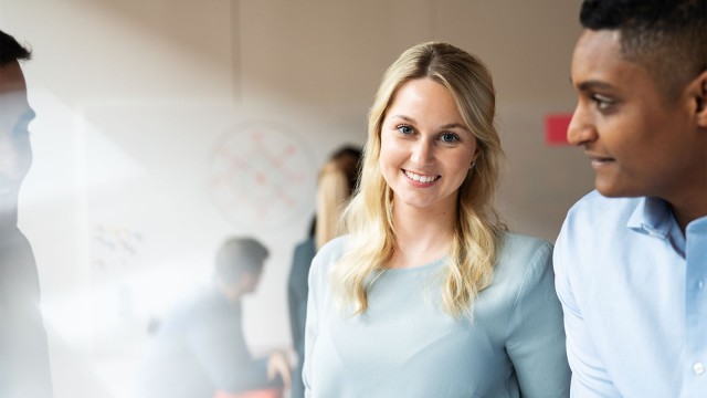 Junge Frau schaut lächelnd in die Kamera