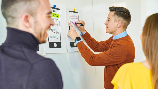 Junger Mann schreibt an Whiteboard