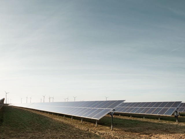 Windräder hinter Solarpanelen