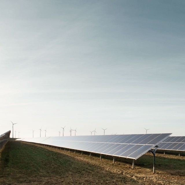 Windräder hinter Solarpanelen 