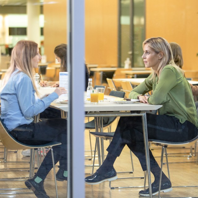 Personen, die in der Cafeteria sitzen