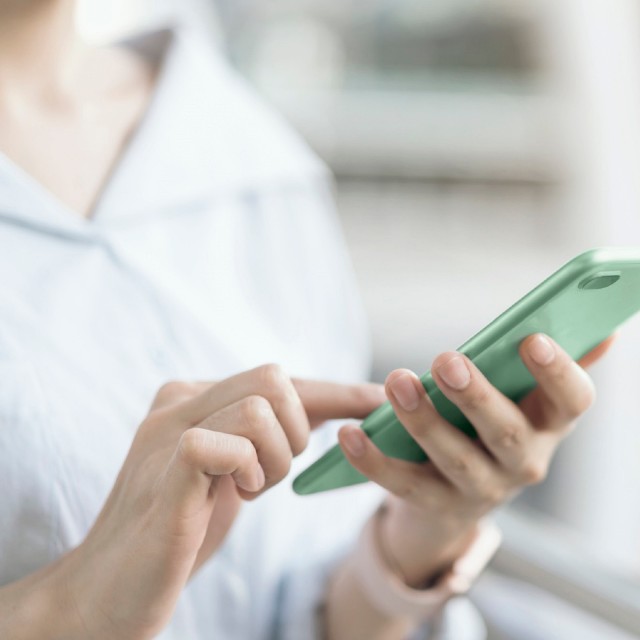 Eine Frau hält ein Smartphone in der Hand