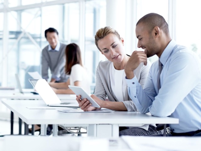 Man and woman reading in a tablet during a meeting