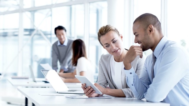 Man and woman reading in a tablet during a meeting