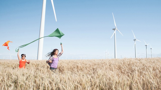 Children running in the fields in front of windmills