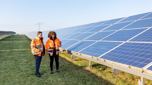Zwei Arbeiter stehen vor einer Photovoltaik Anlage