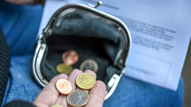 Arme ältere Frau zählt einige Euro und Cents Münzen in der Hand