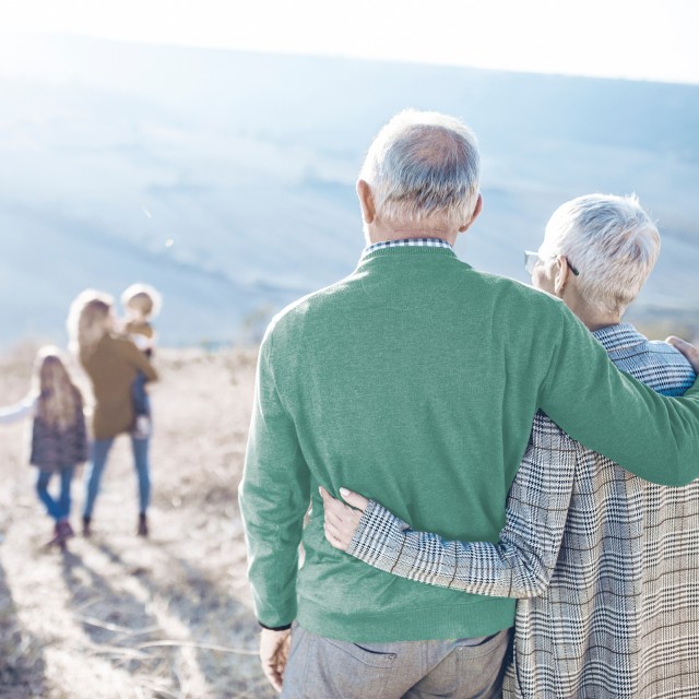 Rentnerpaar blickt auf eine Familie