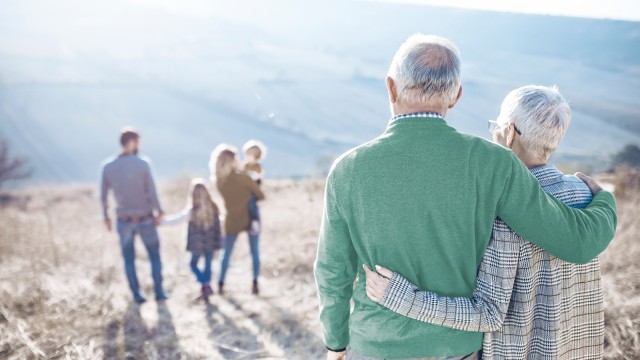 Rentnerpaar blickt auf eine Familie