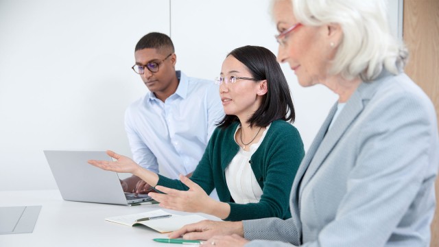 Drei Personen diskutierend am Tisch