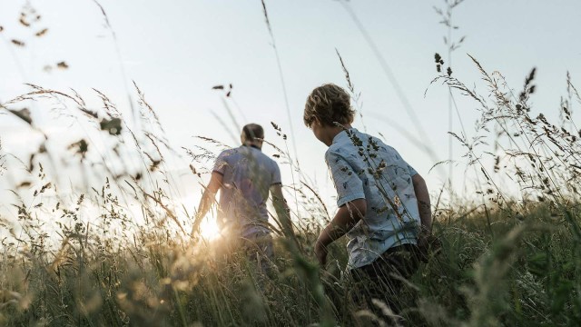 Zwei Personen laufen durch das hohe Gras