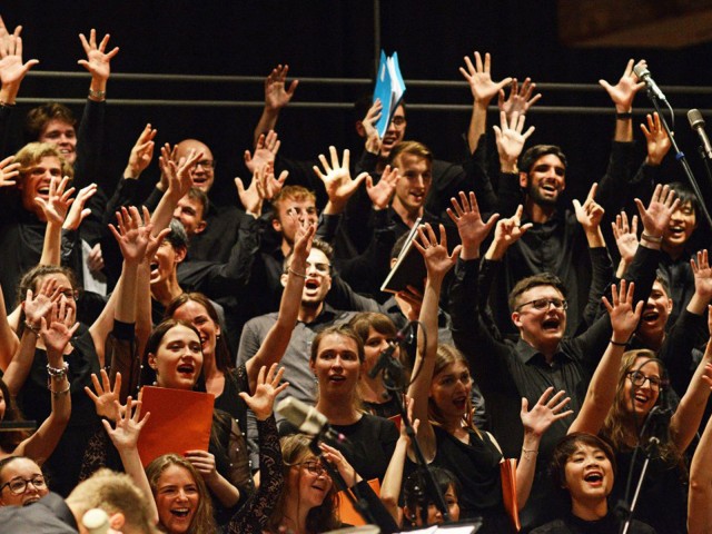 Chorsänger strecken die Hände in die Luft