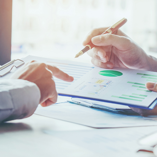 Gesch&auml;ftsleute diskutieren Grafiken am Schreibtisch im Meeting