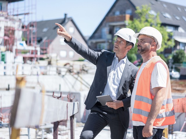 Zwei Männer unterhalten sich auf einer Baustelle
