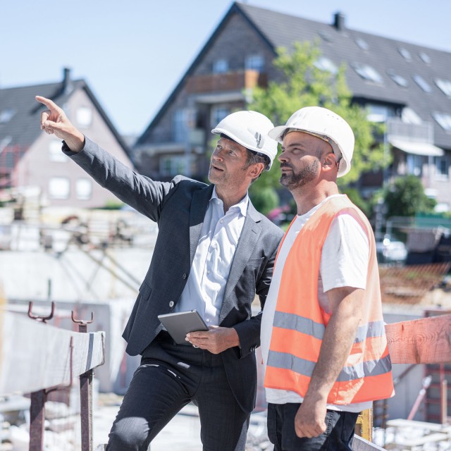 Zwei Männer unterhalten sich auf einer Baustelle