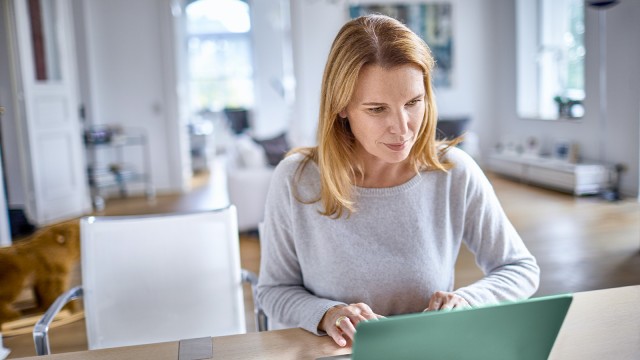 Frau sitzt mit Laptop im Homeoffice