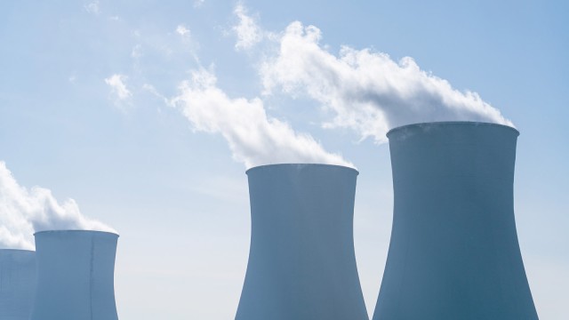 Rauchende Kühltürme vor blauem Himmel