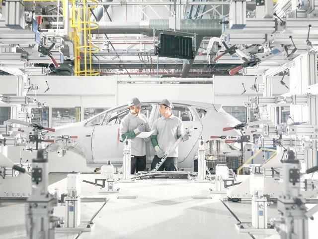 Zwei Mitarbeiter in PKW-Produktionsstätte