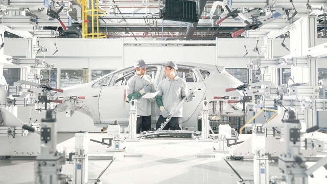 Zwei Mitarbeiter in PKW-Produktionsstätte