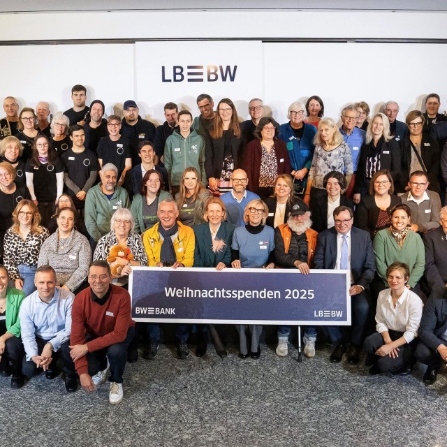 Viele lächelnde Menschen bei Spendenübergabe