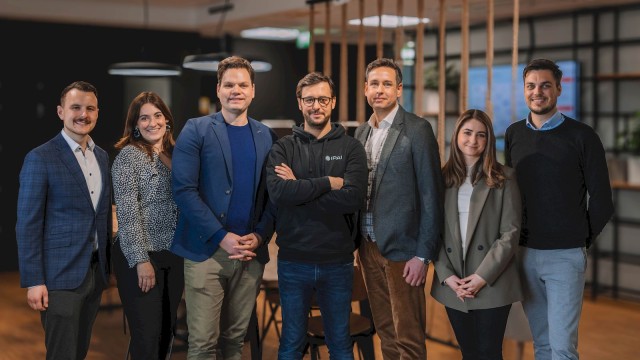Sieben Personen lächeln auf einem Gruppenfoto