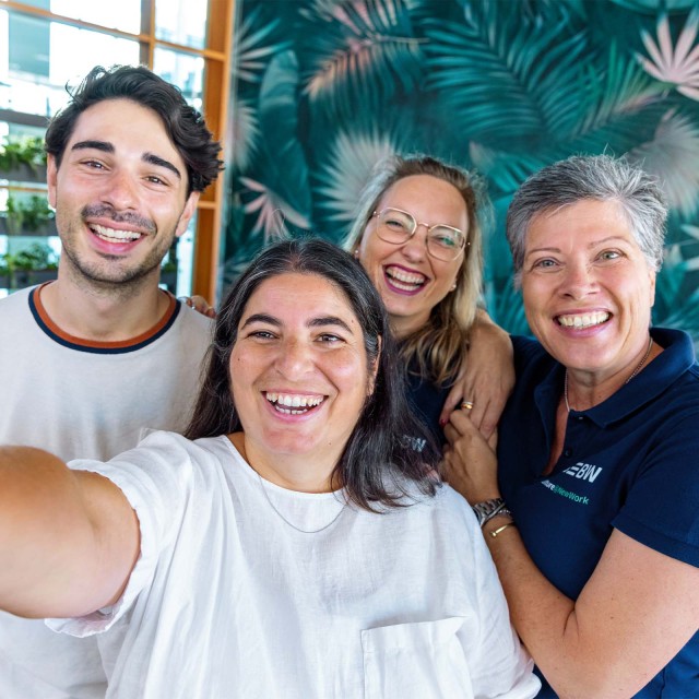 Team macht Selfie und lacht in die Kamera