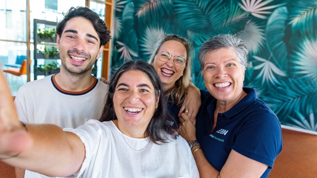 Team macht Selfie und lacht in die Kamera