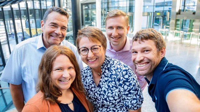 Ein Team aus fünf Personen macht ein Selfie