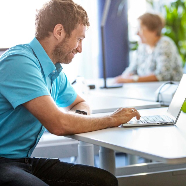 Zwei Menschen arbeiten remote vor Laptop 