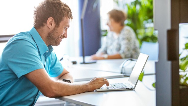 Zwei Menschen arbeiten remote vor Laptop 