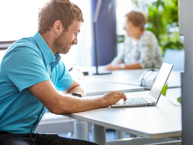 Zwei Menschen arbeiten remote vor Laptop 