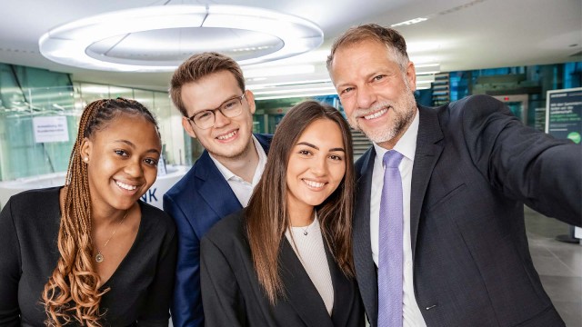 Vier Personen lächeln und machen ein Selfie