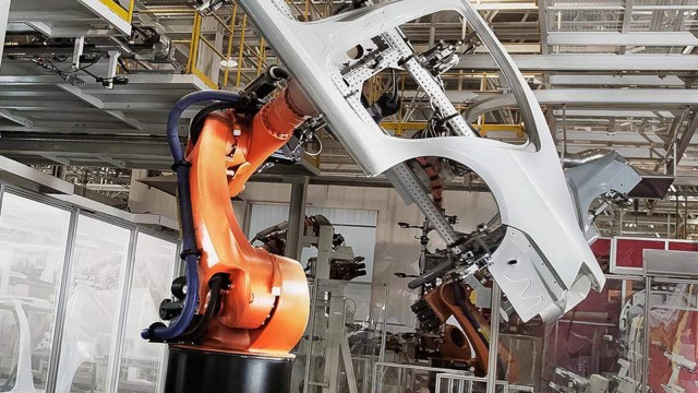 Roboter hebt Autokarosse