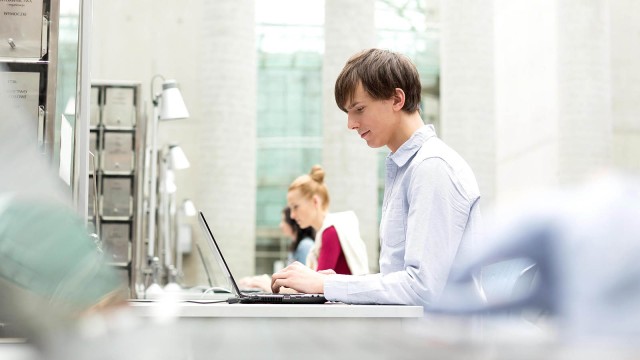 Junge Menschen arbeiten an Laptops 