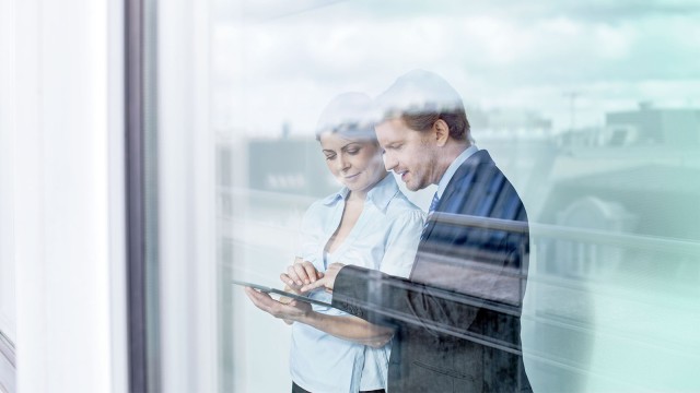 Man and woman looking at a notebook together