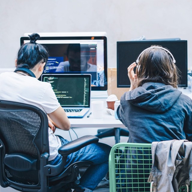 Zwei Hacker vor Computer von hinten