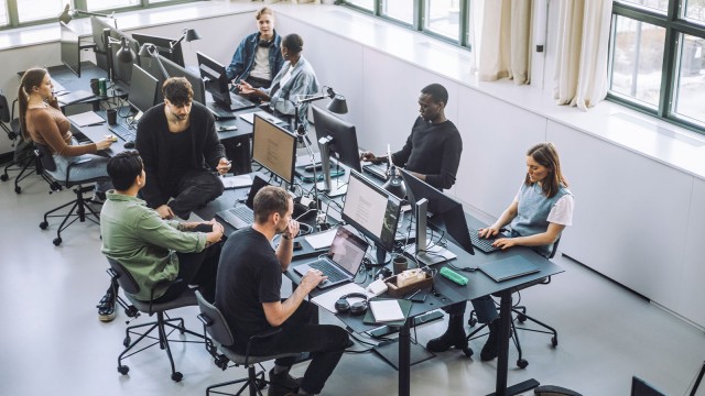Junge Leute mit Laptops und Computern in lockerer Start-up-Atmosphäre