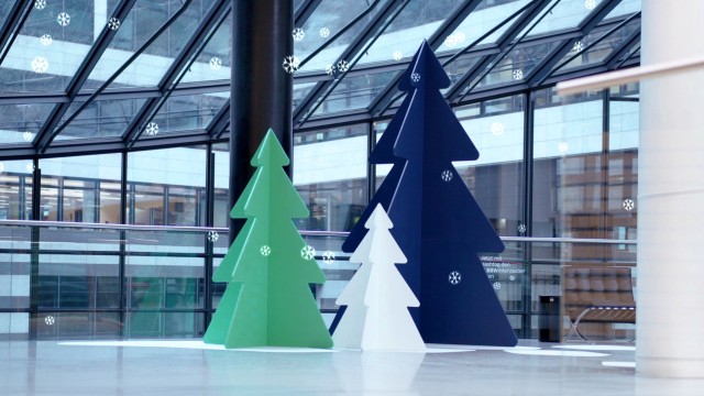 3 künstliche Weihnachtsbäume an einem Empfang eines Gebäudes