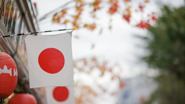Japanische Flagge und rote Laternen in einer Stra&szlig;e in Tokio