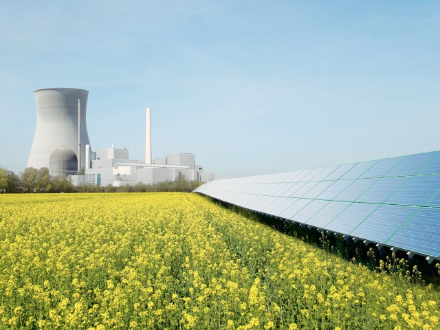 Kraftwerk mit Solaranlage und Wiese davor