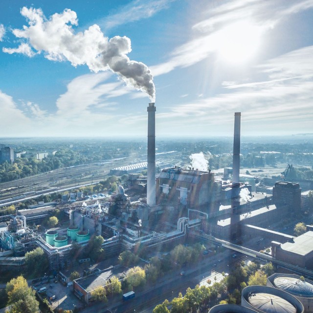 Refinery with smoke and blue sky