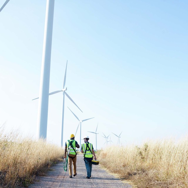 Bauarbeiter laufen in einen Windpark