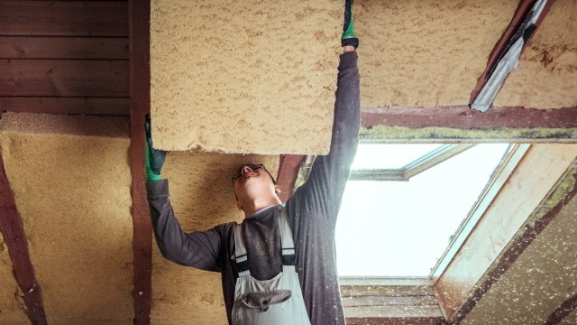 Handwerker baut Dämmung ans Dach